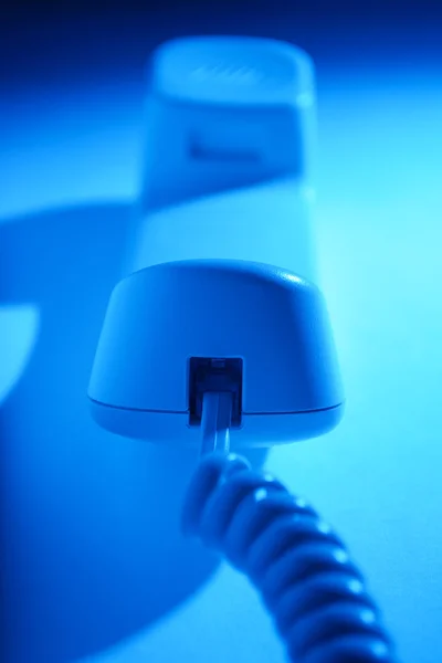 Telefono portatile e cavo in luce blu — Foto Stock