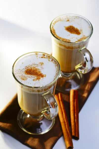 Two mugs of frothy hot chocolate with cinnamon — Stock Photo, Image