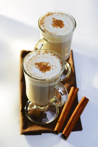 Two mugs of frothy hot chocolate with cinnamon — Stock Photo, Image