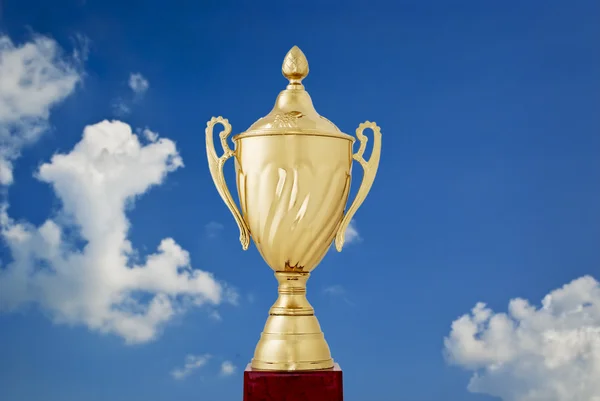 Golden cup against a blue sky — Stock Photo, Image
