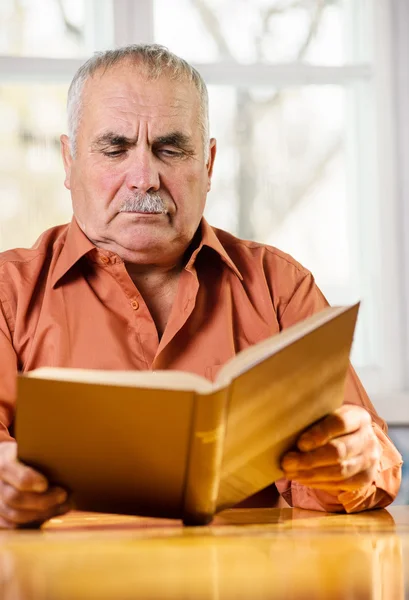 Senior man läser en bok — Stockfoto