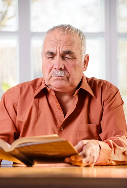 Senior man läser en bok — Stockfoto