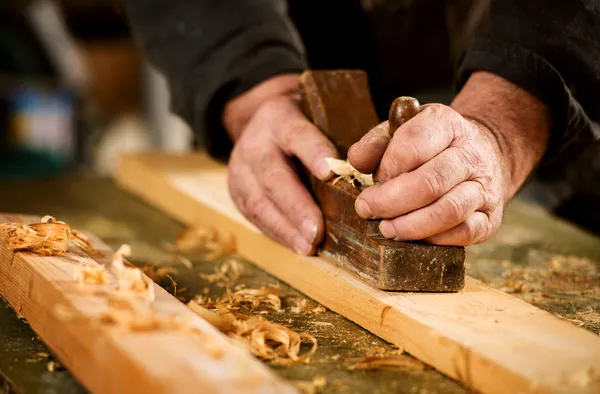 Skilled carpenter using a handheld plane — Stock Photo, Image