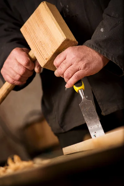 Timmerman of de schrijnwerker met een beitel en hamer — Stockfoto