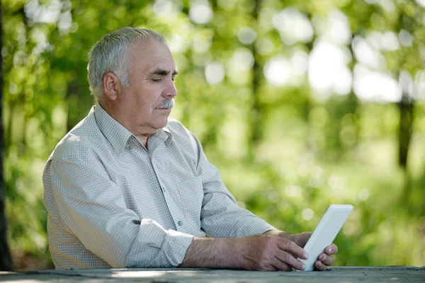 Äldre man surfar på internet på en Tablet PC — Stockfoto