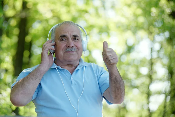 Щасливий старший чоловік слухає музику — стокове фото