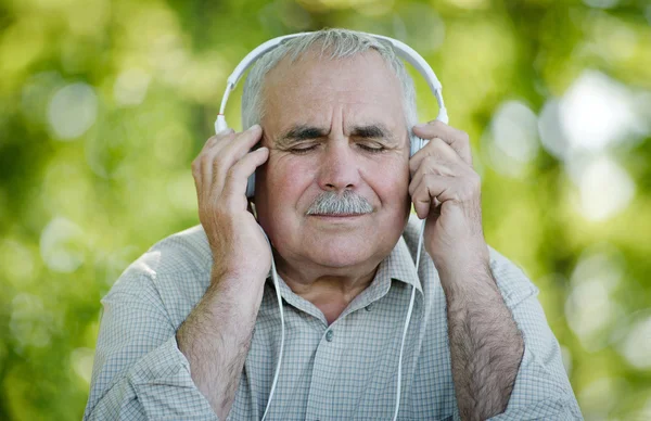 Gepensioneerde m/v genieten van zijn muziek — Stockfoto