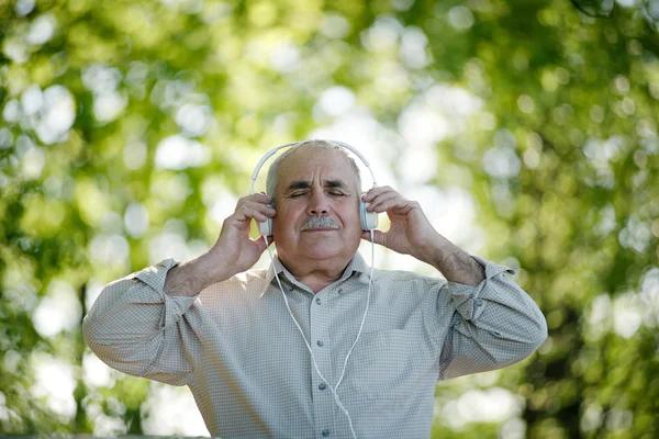 Блаженний старший чоловік слухає музику — стокове фото