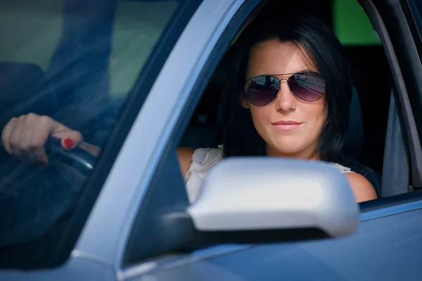 Stylish young woman in sunglasses driving a car Royalty Free Stock Images