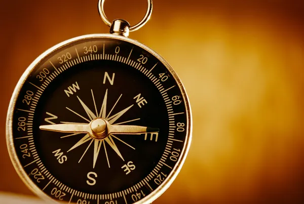 Magnetic compass against a vintage background — Stock Photo, Image