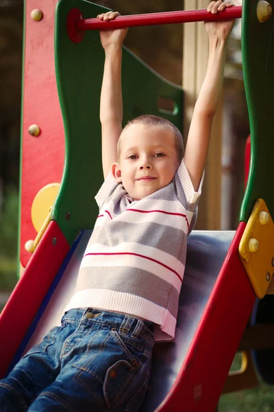 Cute little boy about to take a ride on a slide — Stock Photo, Image