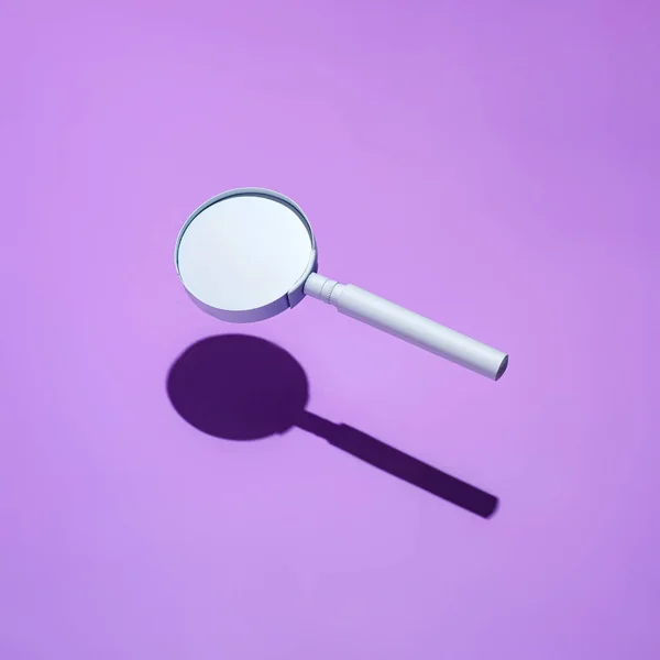 用白色透镜浮出放大镜 并将阴影投在有复制空间的正方形紫色背景上 — 图库照片