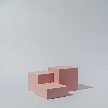 Gri arkaplanda ürünleri veya kozmetikleri görüntülemek veya göstermek için podyum duruşu geometrik küp platformu