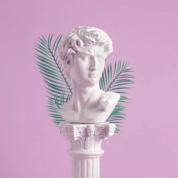 古式的罗马或希腊式的白色半身像 位于棕榈叶背的华丽基座上 粉红的背景上 呈正方形 — 图库照片