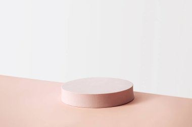 Ürün yerleştirme ve reklam kavramı. Boş ekran. Beyaz bir duvara karşı dairesel bej kaidesi var.