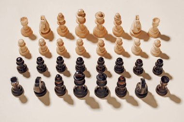 Satranç oyunu siyah ve beyaz, bej bir arka planda dövüşmeye hazır. Asgari zafer ve başarı yarışması konsepti.