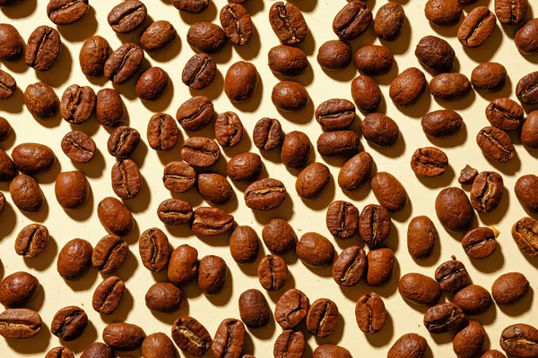 Tam Kavrulmuş Kahve Çekirdeklerinin Arka Plan Dokusu Bej Bir Arkaplan — Stok fotoğraf