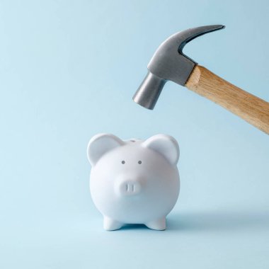The piggy bank as a symbol of savings and income will hit the hammer. Minimal creative pastel concept of debit and investment deposit and market crisis and fall problems.