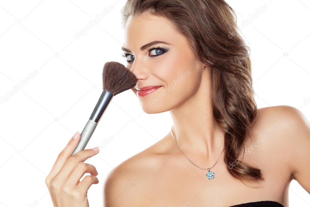 Woman joking with a make-up brush