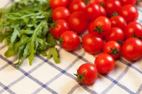 Tomatoes and rucola on towel — Stock Photo, Image