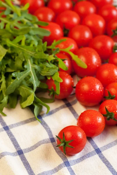 Tomates e rúcula na toalha — Fotografia de Stock