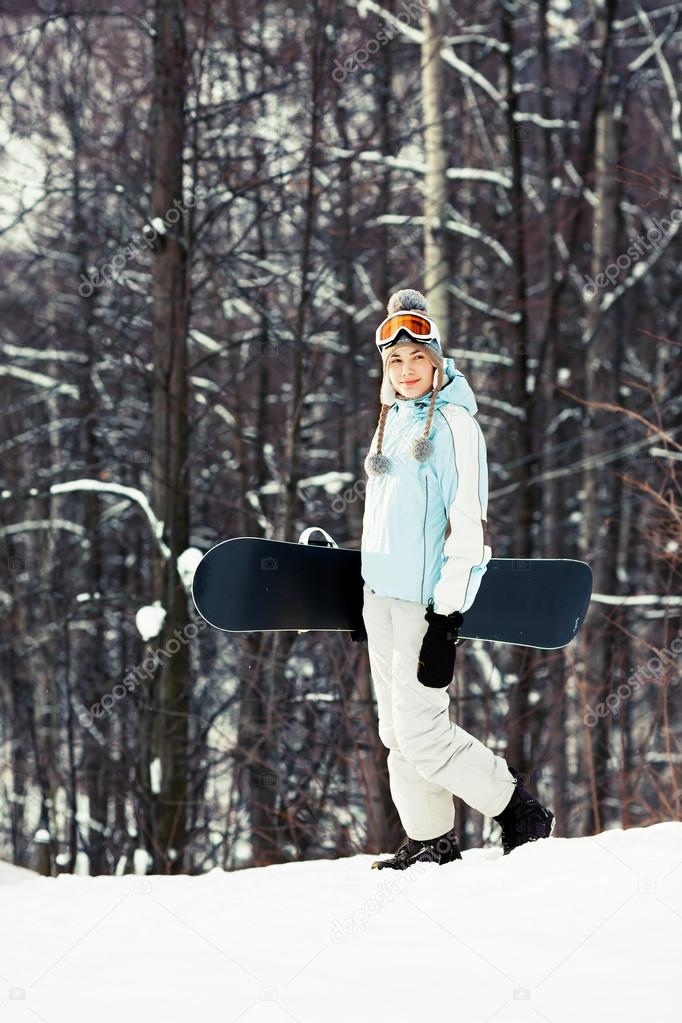 Young woman with snowboard on ski slope