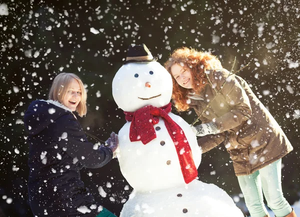 Dwóch młodych kobiet, budowa snowman — Zdjęcie stockowe