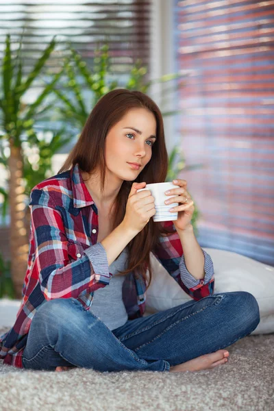 Junge Frau hält eine Tasse — Stockfoto