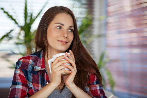 Jeune femme tenant une tasse — Photo