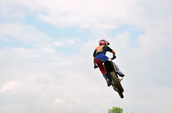 Motocross racer flies amid the clouds — Stock Photo, Image