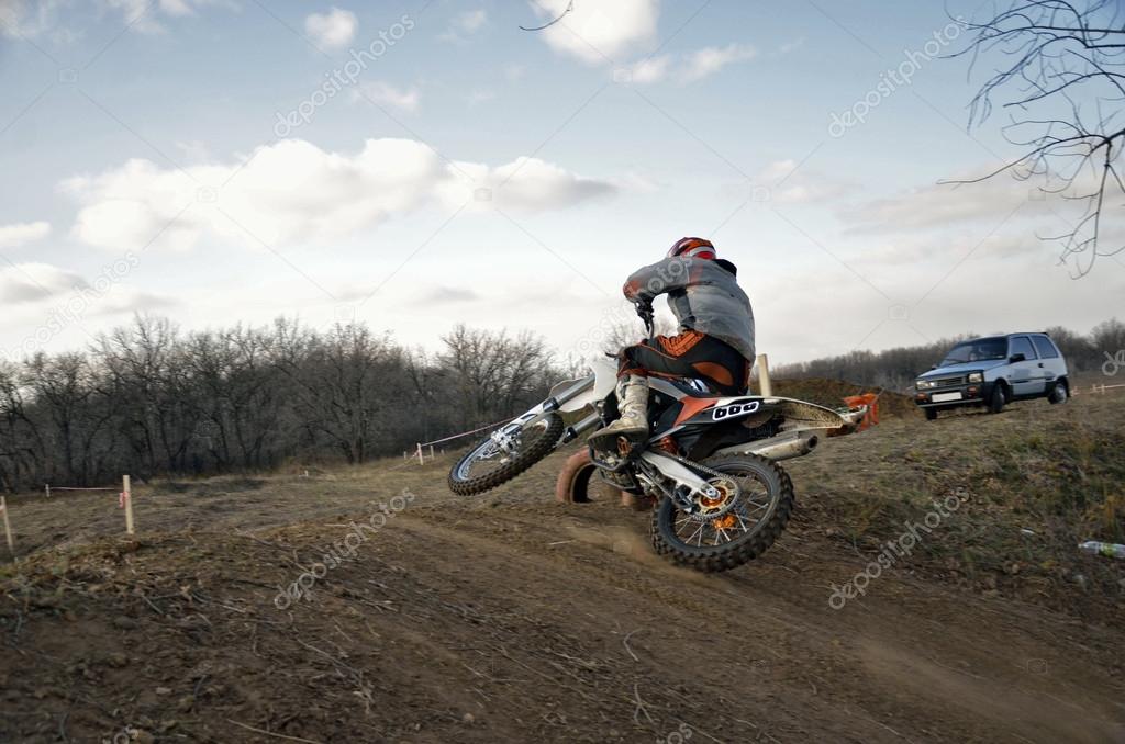 MX rider on a motorcycle rides mound performs scrub