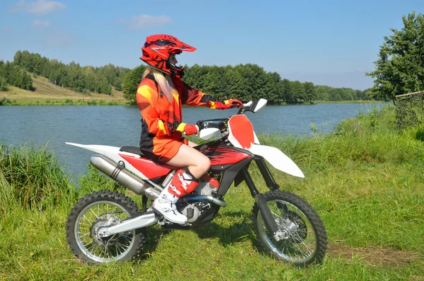 göl ve orman ortasında bir spor bisiklet üzerinde oturan kız.