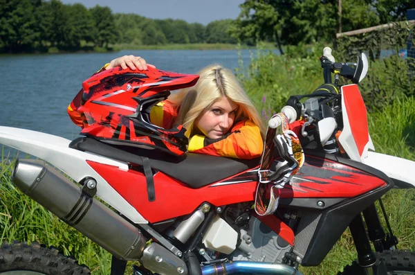 モトクロスのバイクに身を乗り出して立っている女の子です。 — ストック写真