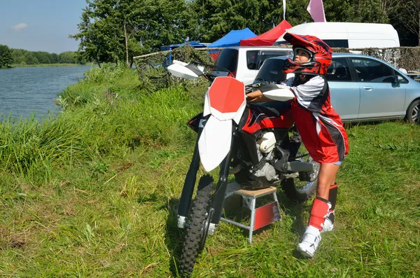 Meisje in een helm kost ongeveer motorfiets motocross. — Stockfoto