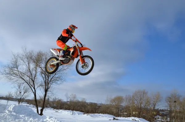 Motocross-Winter, hochfliegender Motorradrennfahrer über Schneeverwehungen — Stockfoto