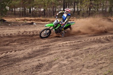 MX rider turns point-blank of sand clipart