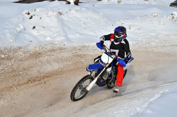 Motocross on snow racer on a motorcycle in the left turn having — Stock Photo, Image