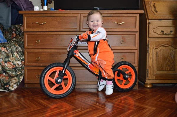 küçük çocuk bir denge bisiklet üzerinde oturur