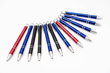 Beyaz arkaplana dizilmiş metal kalemler