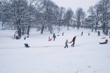 Sibiu, Romanya - 12 Ocak 2019. Kış zamanı kar üzerinde oynayan bir grup çocuk ve yetişkin.
