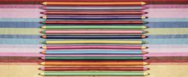 Renkli kağıt arkaplanındaki renkli kalemler