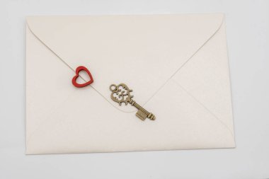 Old key, decorative red heart and paper blank
