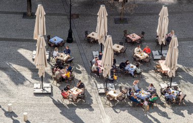 Sibiu City, Romania - 15 April  2022. Outdoor terrace with tables and chairs, aerial top view People sitting and eating together near Sibiu old city center