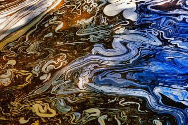 Rainbow colors created by diesel fuel floating on the water