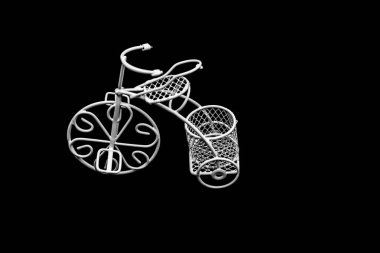 White wire bicycle with a basket  on dark background