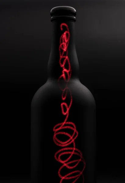 matte black wine bottle with red laser lines painting on dark background