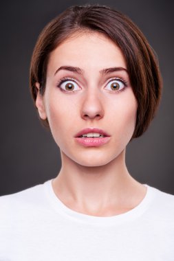 genç kadın koyu arka plan üzerinde hayrete düşürdü.