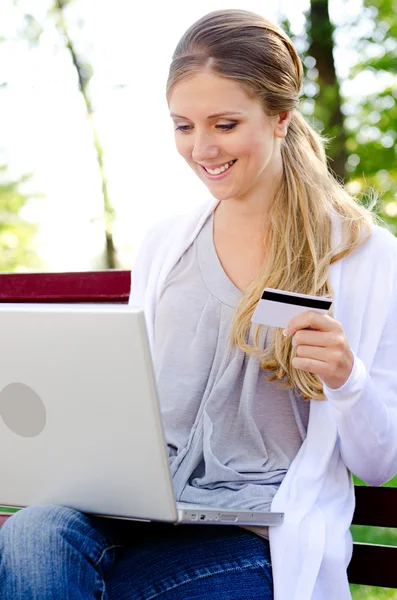 Woman holding credit card and smiling — Stock Photo, Image