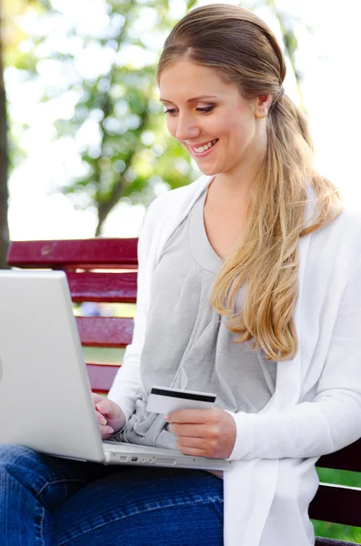 Bilgisayarı ve kredi kartı olan bir kadın. — Stok fotoğraf