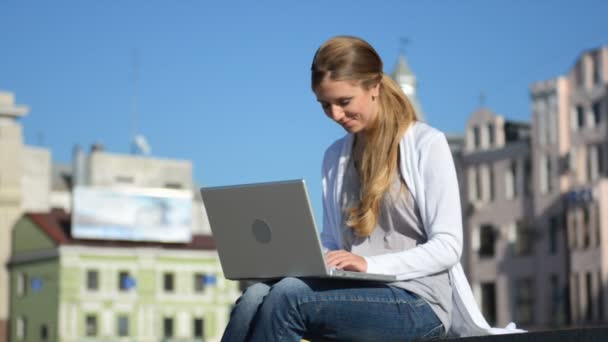 Junge freundliche Frau arbeitet am Laptop — Stockvideo